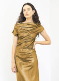 Woman wearing a fashion designer Adrian Hailwood gold metallic dress against a white background